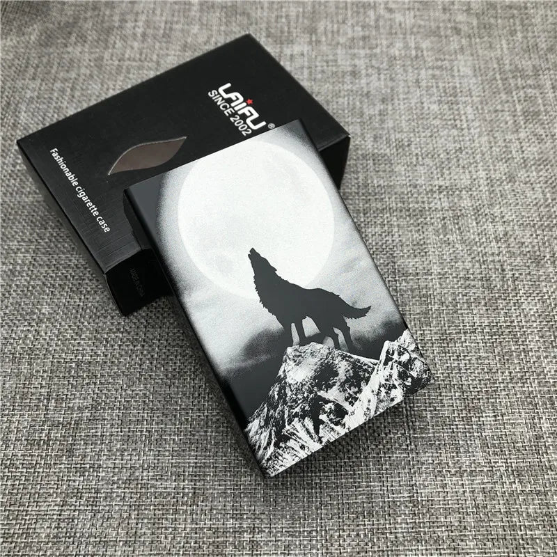 A black and white photograph of a custom engraved cigarette case featuring a silhouette of a wolf against a bright moon and s