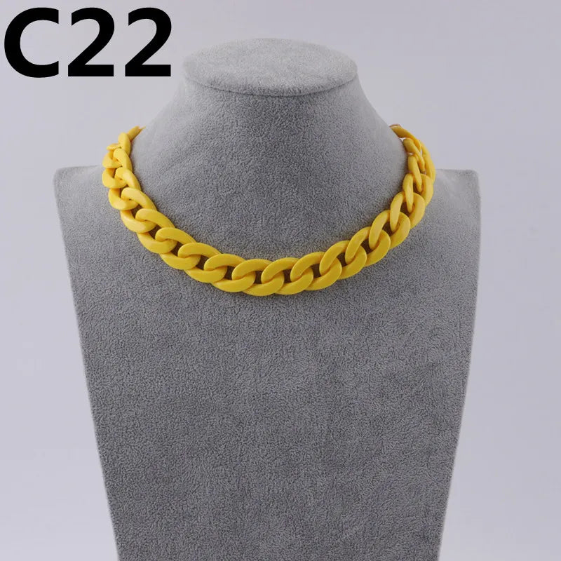 A yellow acrylic link chain necklace displayed on a gray mannequin neck.
