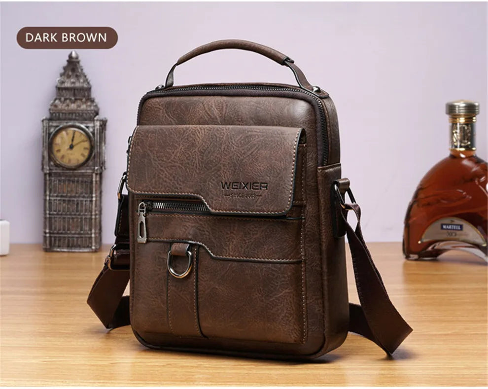 A dark brown vintage PU leather crossbody messenger bag resting on a wooden surface next to a grandfather clock.