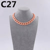 A close-up of a pink acrylic link chain necklace displayed on a gray mannequin neck.