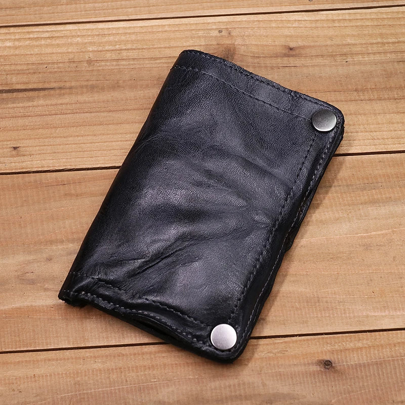 Schwarzes Leder-Bifold-Portemonnaie für Herren auf einer Holzoberfläche.