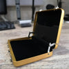 A gold-colored aluminum credit card and ID holder case is open, displaying a black interior.