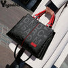 Un sac bandoulière en cuir PU noir avec des accents rouges est tenu par une personne sur un fond clair.