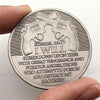 An antique silver plated commemorative coin featuring a depiction of two pistols and a biblical verse.