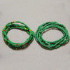 Two strands of colorful green and red belly bead chains laid out on a light background.