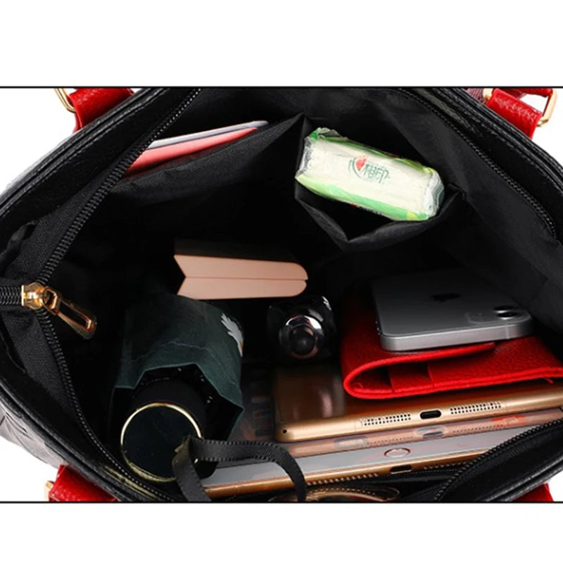 Intérieur d'un sac bandoulière en cuir PU noir montrant divers accessoires comme un carnet, un téléphone et un tissu rouge.