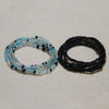 Two strands of colorful belly bead chains, one light blue and black, and one entirely black.