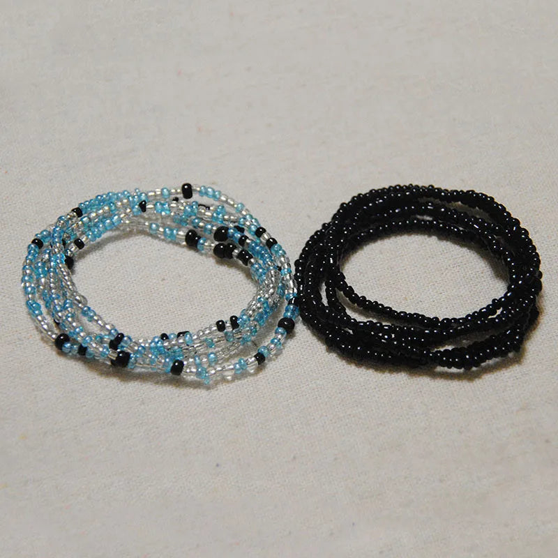 Two strands of colorful belly bead chains, one light blue and black, and one entirely black.