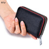 A hand holds a black accordion card holder wallet with a red and black zipper on the side.