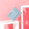 A light blue compact PU leather zip wallet with a gold chain keychain resting on a white surface.