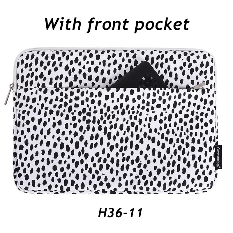 A black and white spotted laptop sleeve with a front pocket.