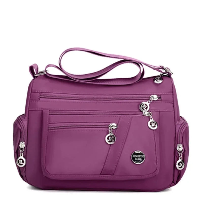 A purple waterproof nylon crossbody tote bag for women.