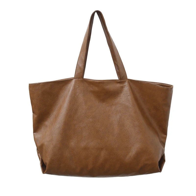 A brown oversized PU leather tote bag with a handle is shown from the front.