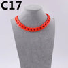 A bright orange acrylic link chain necklace displayed on a gray mannequin neck.
