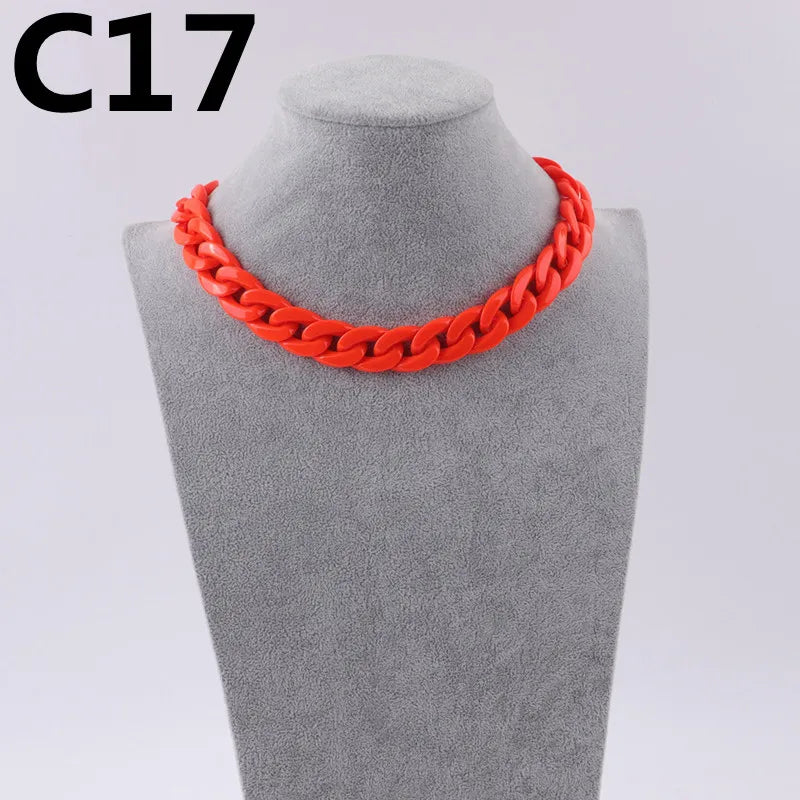 A bright orange acrylic link chain necklace displayed on a gray mannequin neck.