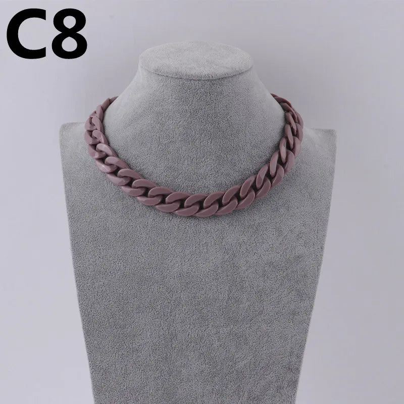 A close-up of a pink acrylic link chain necklace displayed on a mannequin neck.