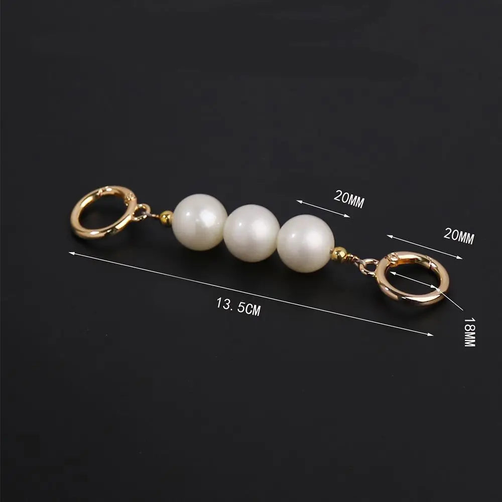 Sangle de sac perles ton or avec chaîne et multiples perles blanches rondes.