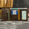 A brown leather trifold wallet with a detachable chain is shown open, displaying various credit cards and identification docu