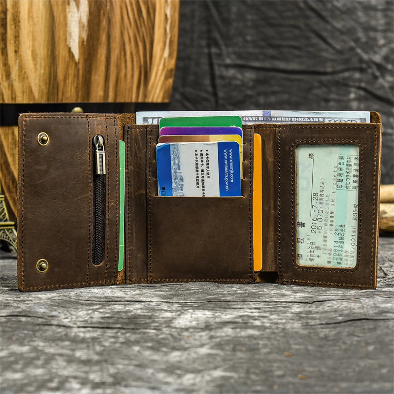 A brown leather trifold wallet with a detachable chain is shown open, displaying various credit cards and identification docu