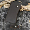 A dark brown genuine leather bifold wallet with a metal chain is displayed on a dark gray textured surface.