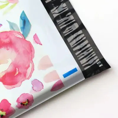Vue rapprochée de pochettes d'envoi à motif floral scellées, avec une bande de code-barres noire sur le côté.