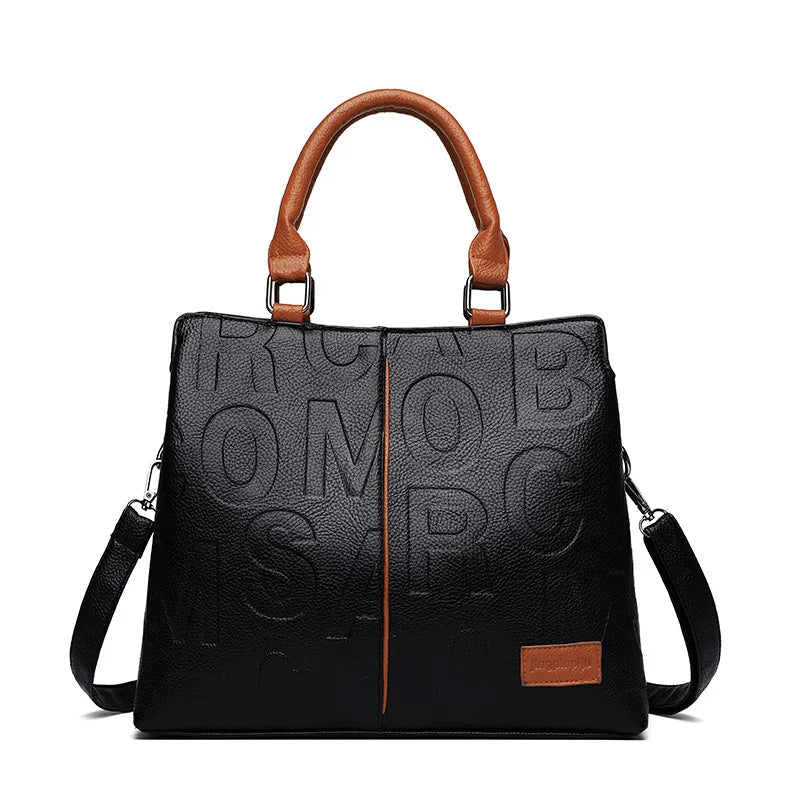 Sac bandoulière en cuir PU noir avec poignée en cuir marron et coutures d'accent.