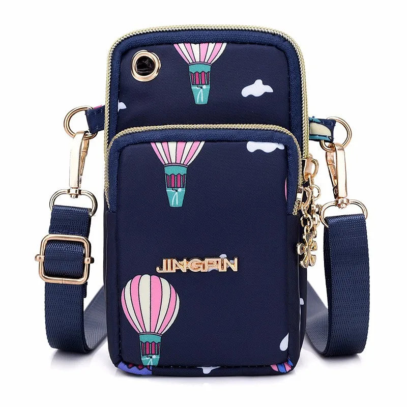 Navy waterproof nylon crossbody bag featuring pink and green striped hot air balloon designs