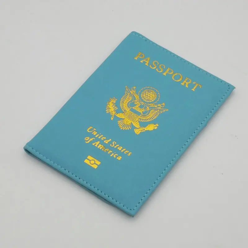 A teal leather passport holder with gold lettering and an eagle emblem, featuring the flag of the United States of America.