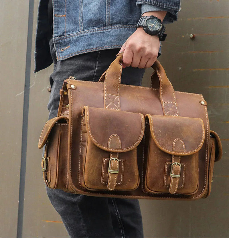 A brown genuine cowhide leather briefcase with leather straps and pockets carried by a person.