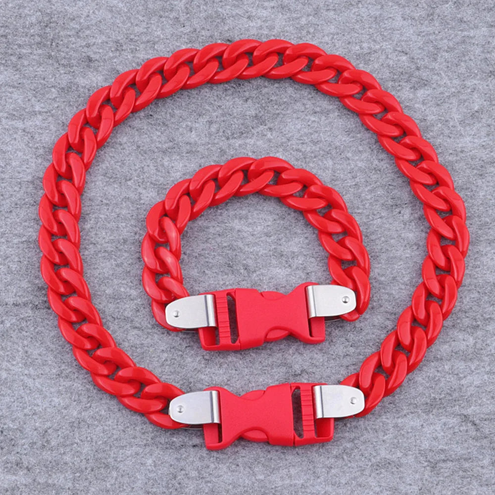 A red acrylic link chain necklace coiled in a circle on a gray background.