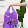 Un sac de shopping violet avec un dessin d'hibou tenu par une main à côté de grandes feuilles vertes.