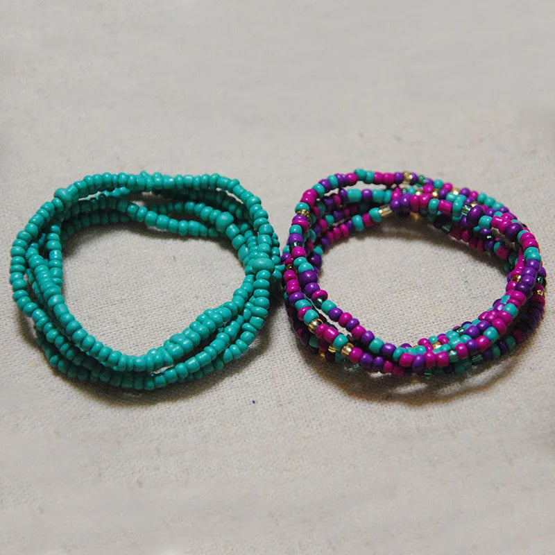 Two bracelets made of colorful belly beads, one turquoise and one purple.