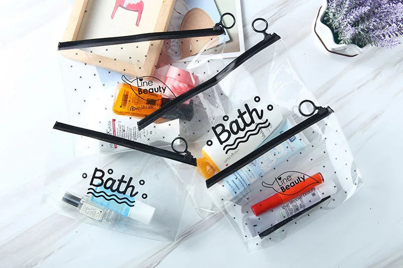 Bolsa de plástico transparente con asas negras que contiene productos de belleza como loción y crema.