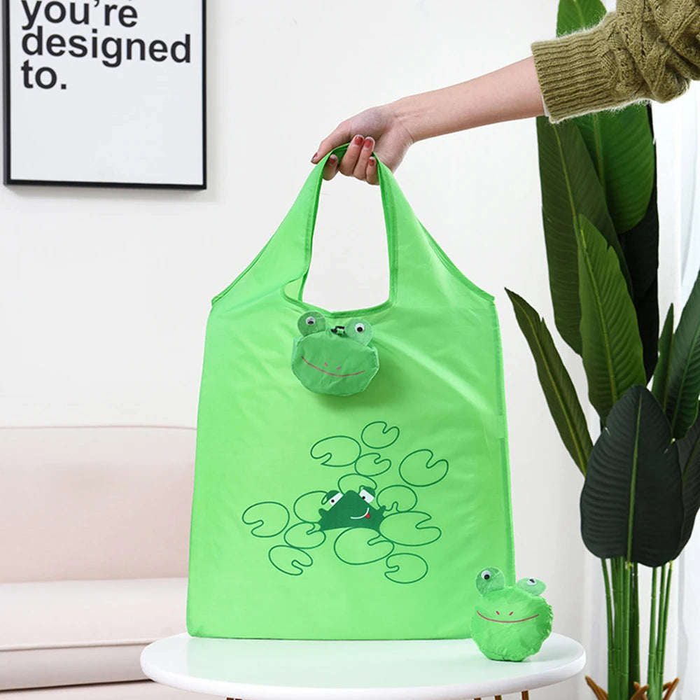 Un sac de courses réutilisable vert lime avec un dessin de grenouille de dessin animé, tenu par une personne.