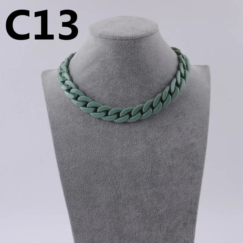 A close-up of a green acrylic link chain necklace displayed on a gray mannequin neck.