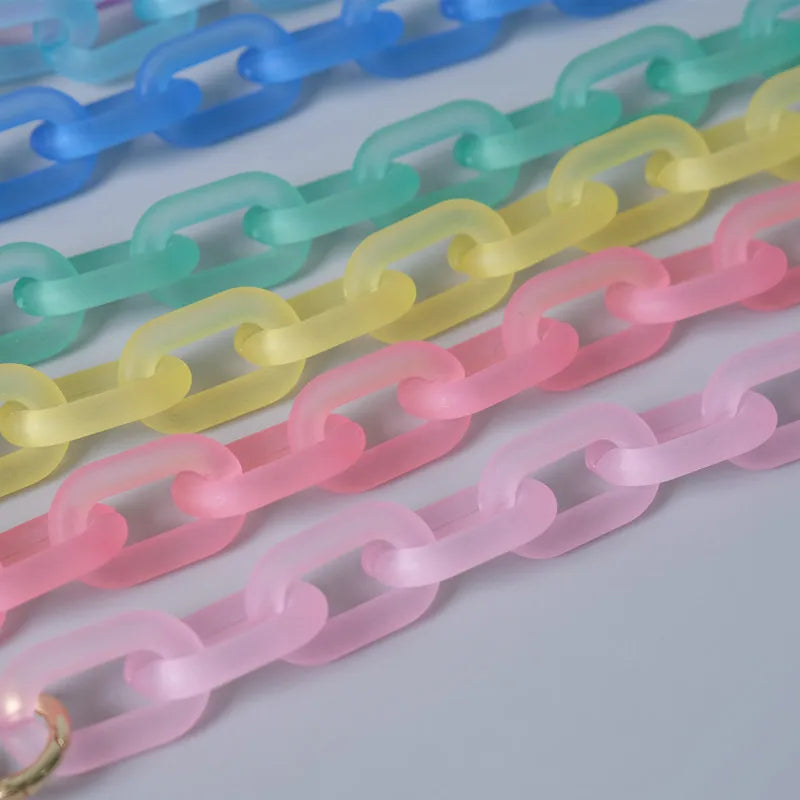 A collection of colorful, adjustable detachable chain shoulder bags arranged in a diagonal line.