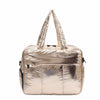 A large capacity women's travel duffle bag in shiny gold metallic material.