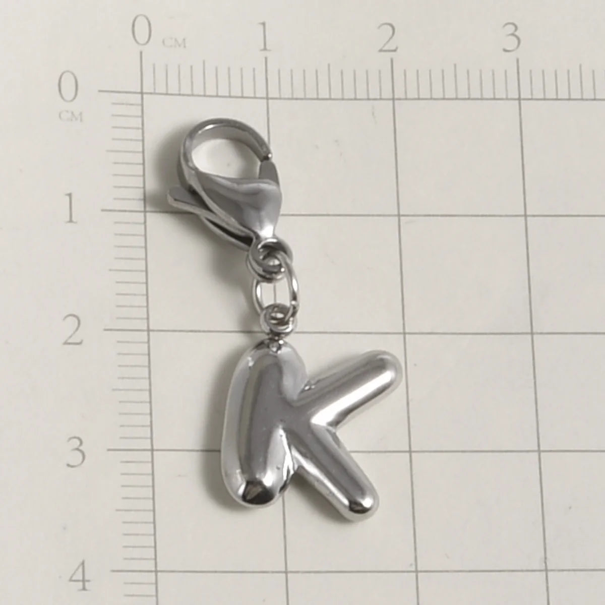 Silver stainless steel alphabet letter charm shaped like the letter K with a lobster clasp