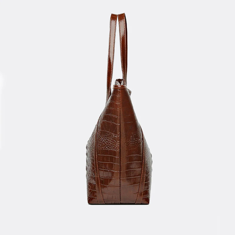 A brown crocodile print tote bag with a top handle shown from the front.