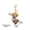 Gold-toned leopard print bow and heart charm keychain.