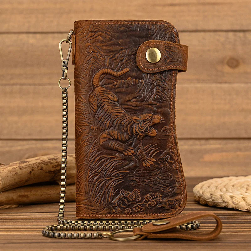 A brown genuine leather bifold wallet featuring an embossed tiger design and a metal chain.