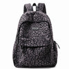 A leopard print laptop backpack with padded straps in black and gray.
