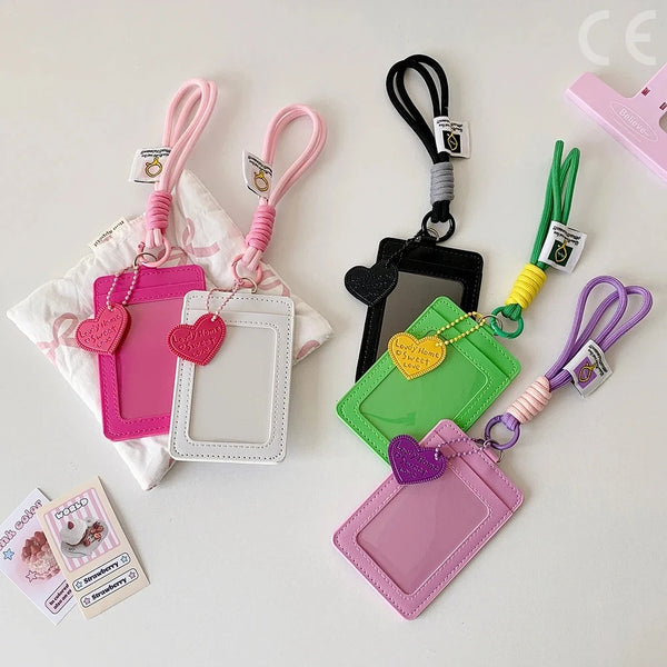 A collection of pink, purple, and green PU leather card holders and ID wallets with various colored keychains.