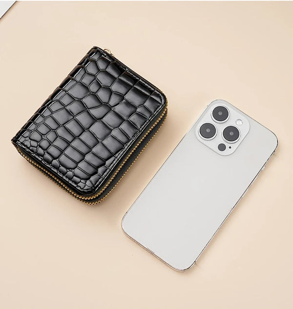 A black crocodile print fashion PU leather double zipper wallet placed next to a white smartphone.