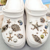Pair of white canvas shoes decorated with various sea-themed charms like starfish and conch shells