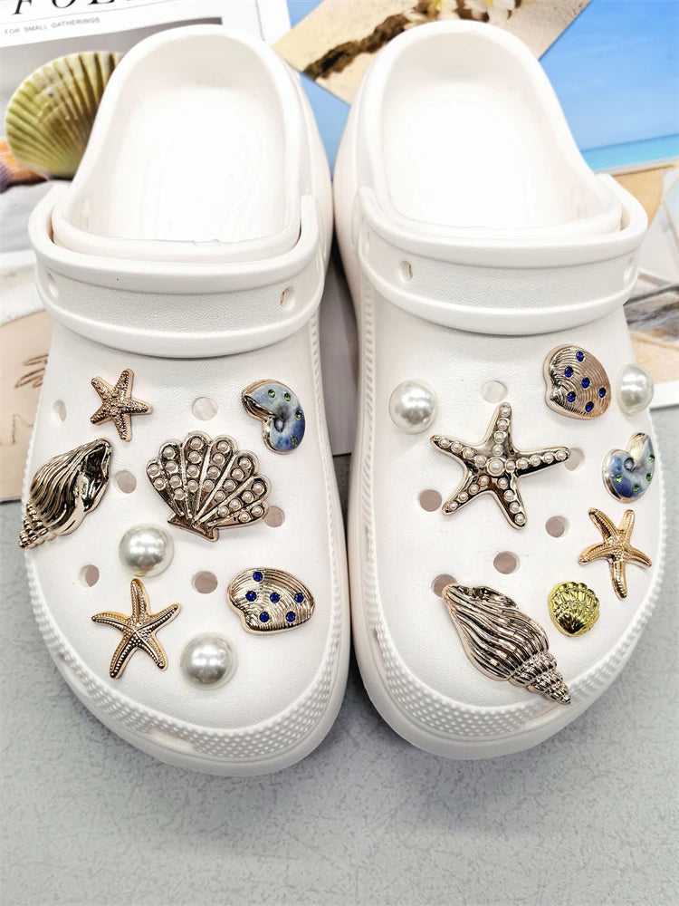 Pair of white canvas shoes decorated with various sea-themed charms like starfish and conch shells