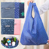A blue polka-dotted reusable shopping bag is shown alongside various fabric bags and a small basket.