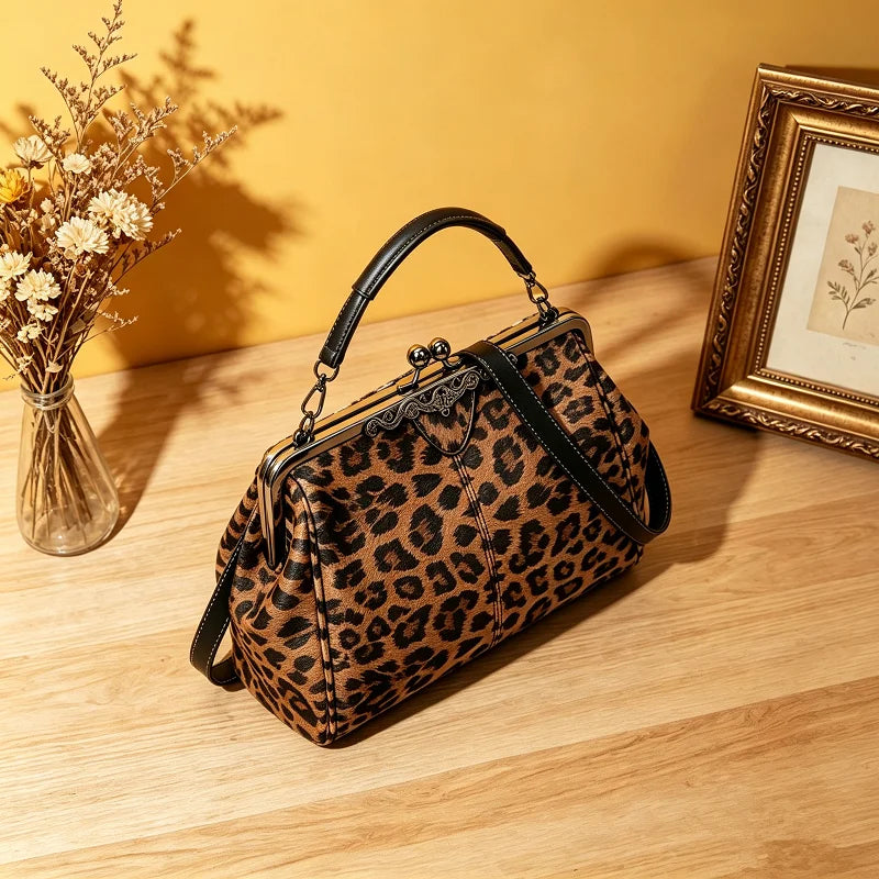 A brown leopard print faux leather handbag with a top handle and crossbody strap resting on a wooden surface.