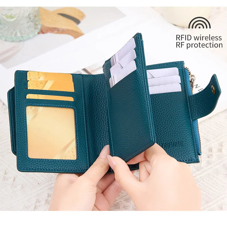 A dark teal RFID blocking card holder wallet is shown open, displaying cards and a transparent window.