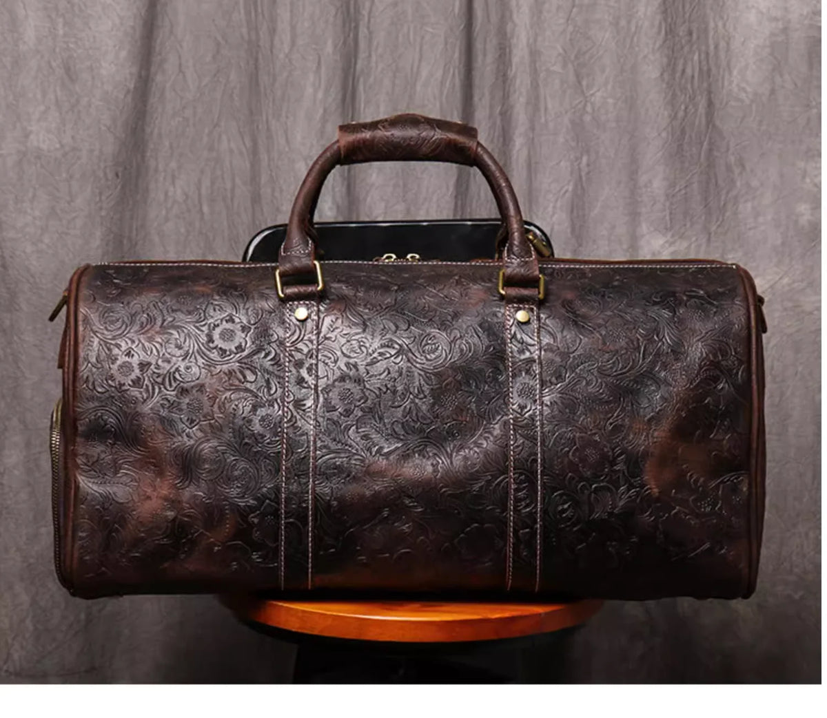Dunkelbraune Vintage-Leder-Totebag mit Lederriemen auf Holzoberfläche.